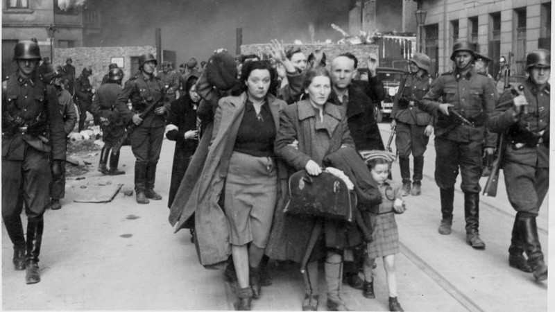 En una de las imágenes más conocidas del Informe Stroop, un grupo de soldados nazis apremia a una familia judía para que abandone el gueto de Varsovia.