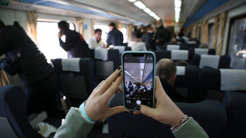 Una pasajera toma una foto con su celular en el viaje protocolar de este viernes. 