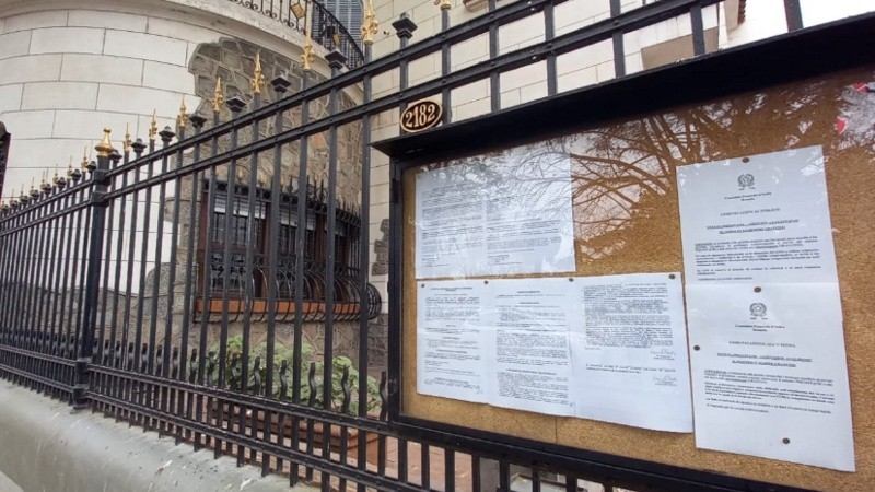 Puertas cerradas e información a través de cartelería fija en el Consulado de Italia en Rosario.