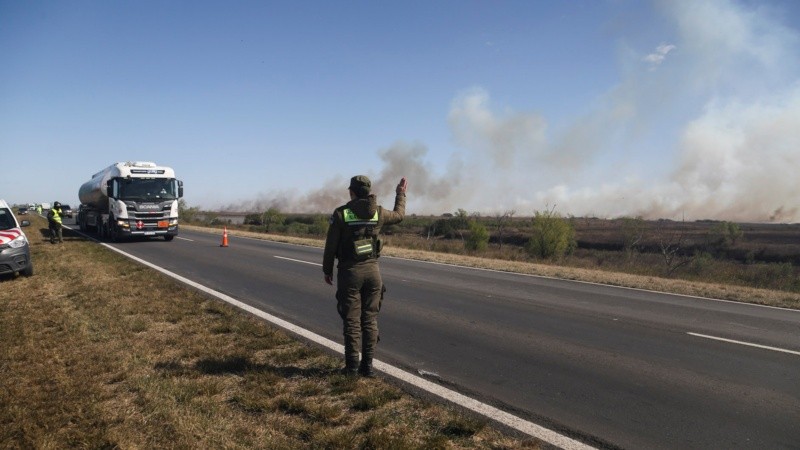 Gendarmería advirtiendo a los conductores que bajen la velocidad por la presencia del humo. 