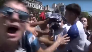 El periodista alemán entre hinchas tratando de hacer el móvil para la TV de su país.