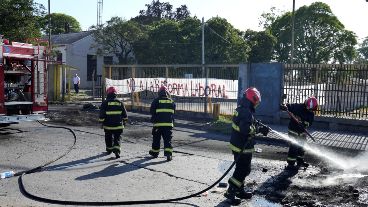Bomberos apagan los neumáticos incendiados para rehabilitar el tránsito. (Alan Monzón)
