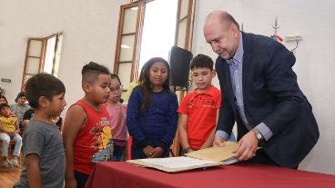El gobernador Perotti y un grupo de chicos de Nuevo Alberdi, durante el acto de apertura de sobres.
