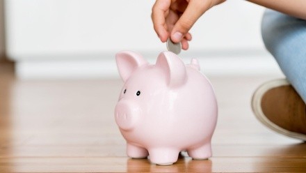 Close up of a boy saving money in a piggybank - home finances concepts-Model and Property Released (MR&PR)