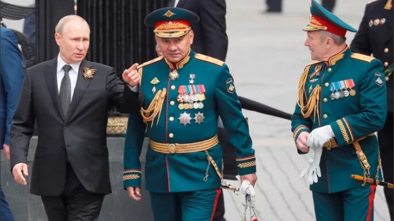 Putin, conversa con el ministro de Defensa, Serguéi Shoigu en un desfile militar en la Plaza Roja de Moscú .