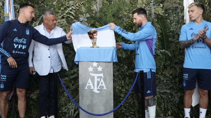 Lisandro Martínez espía como Leo Messi y Scaloni descubren la placa en Ezeiza.