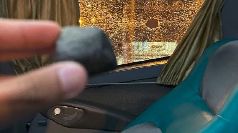 Uno de los futbolistas del Matador mostró una piedra que atravesó un vidrio.