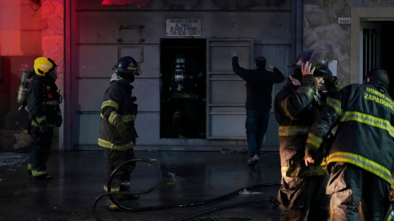 Darío, el dueño del taller familiar, habla con los bomberos que combatieron las llamas.