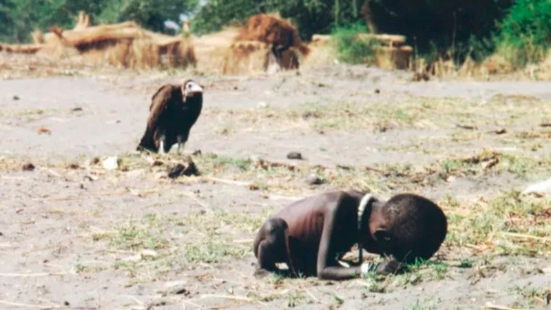 La imagen de una niña sudanesa que se encuentra muriendo de hambre, mientras un buitre se mantiene al acecho, tomada en 1993.