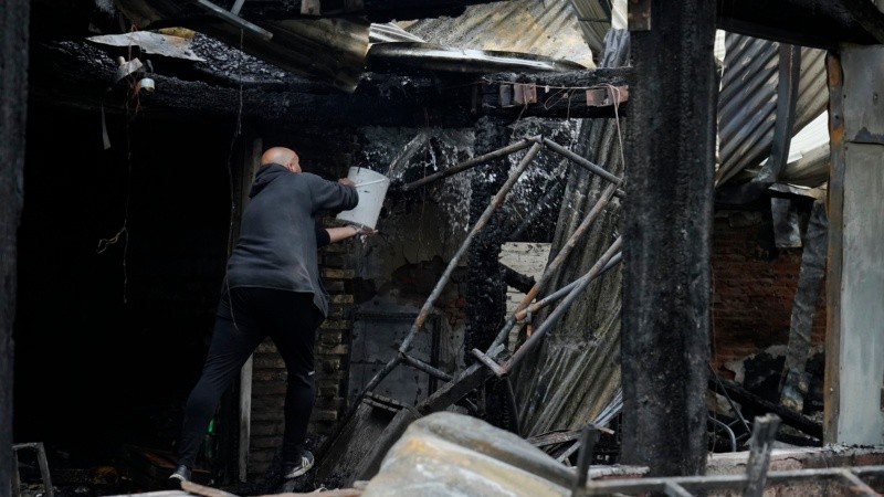 Un empleado trata de apagar un fuego reanimado con un baldazo de agua