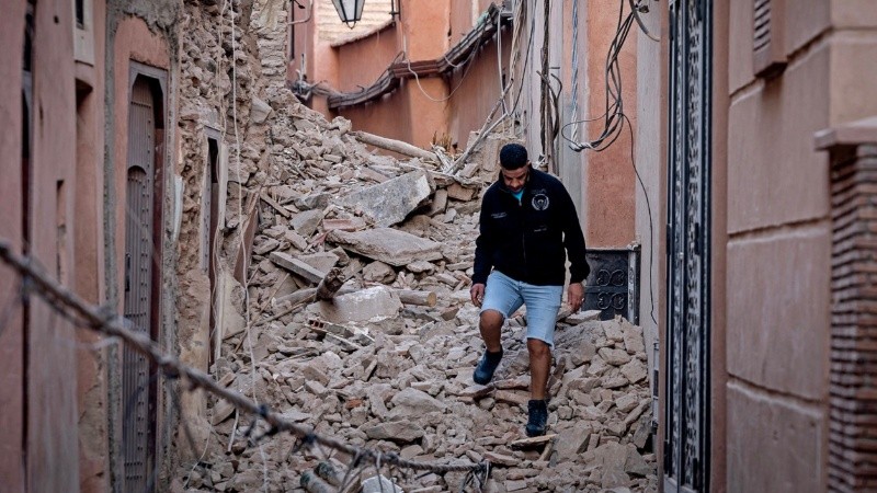 Un residente atraviesa los escombros tras uno de los derrumbes en su pueblo.