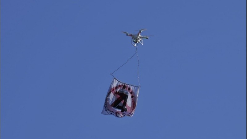 El dron con la bandera sobre el Gigante de Arroyito.