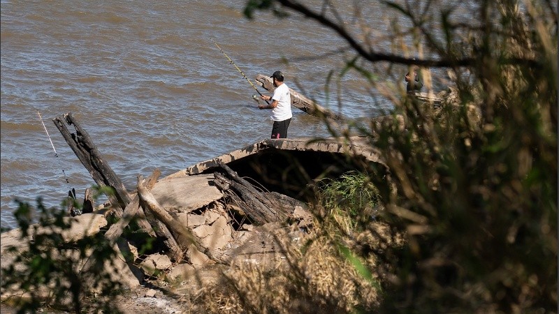 Pescadores de la ciudad y de la región saltan el vallado para hacer su actividad en el muelle derruído.