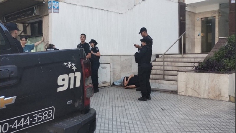 El hombre acostado en los escalones de un edificio en calle Laprida al 800, esposado.
