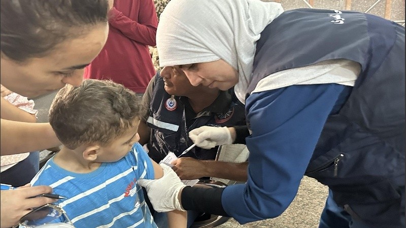 Una médica vacunó a un niño tras cruzar la frontera desde Gaza a Egipto.