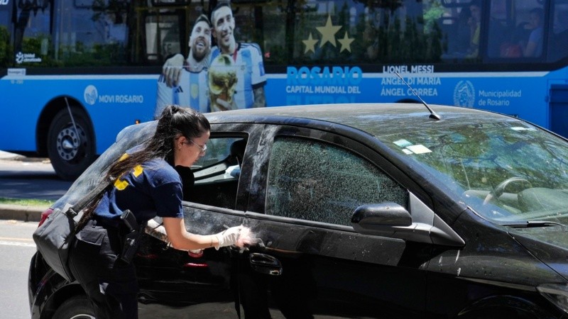 Una foto que habla: policía perita el auto donde iban familiares de Antonela, mientras un colectivos con la imagen de Messi pasa detrás