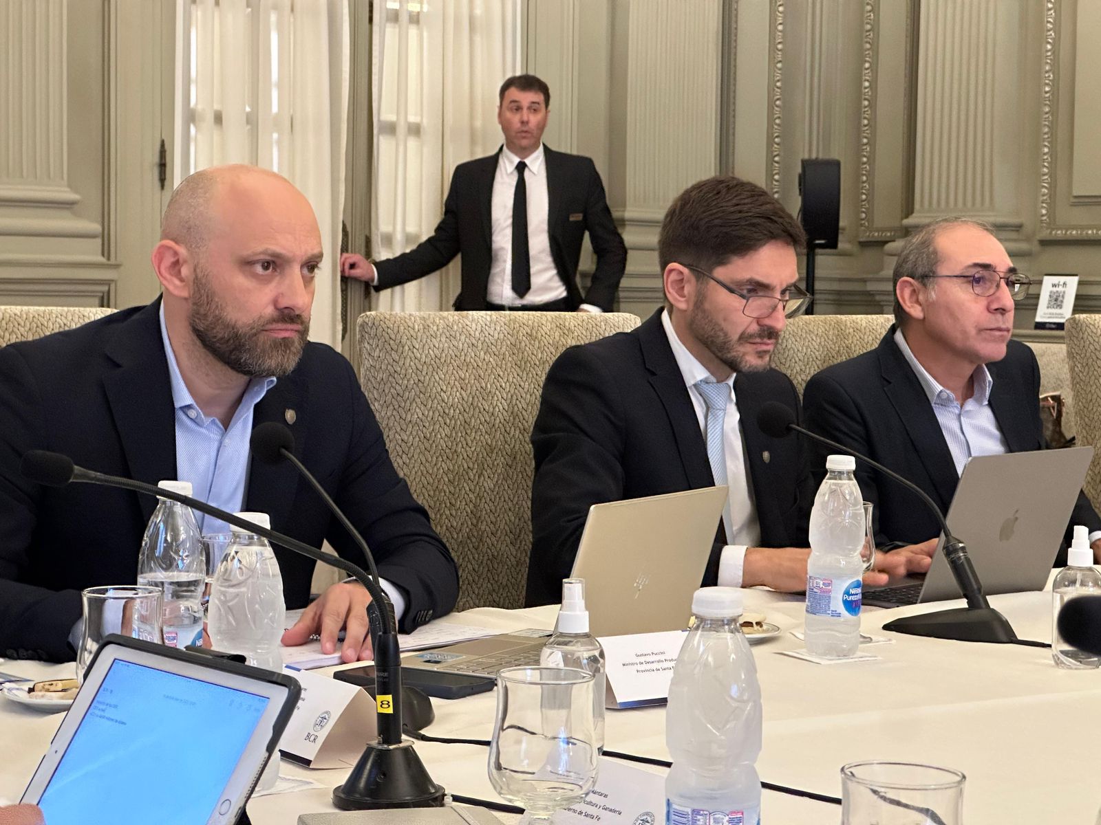 Pullaro, entre su ministro de Desarrollo y el titular de la Bolsa, toma sus propios apuntes de las reuniones