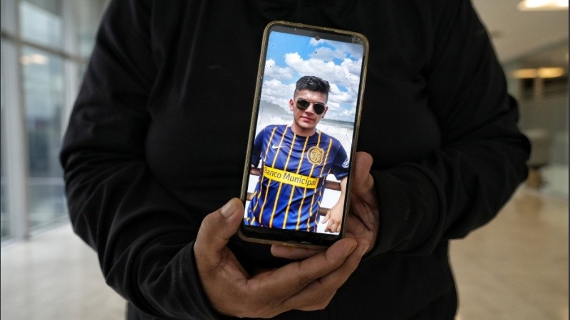  Daniela, la madre de Bruno, quien habló con la prensa y no quiso mostrar su rostro, muestra una foto de su hijo durante el cuarto intermedio de la audiencia.