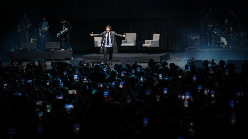 Milei sobre el escenario ante sus seguidores y de fondo la banda musical que lo acompañó.