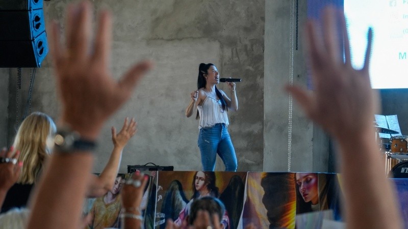 Leda canta alabanzas a su Dios y los asistentes expresan su fe.