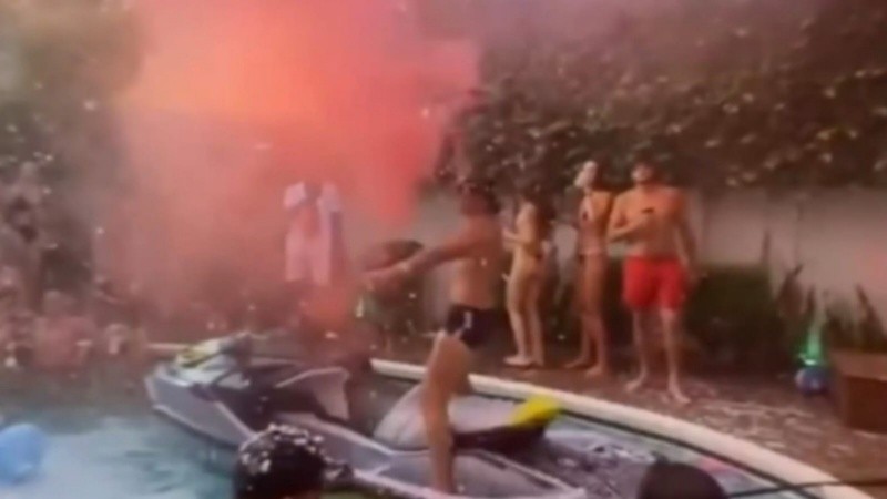 Una moto de agua y bengalas de humo alrededor de la pileta.