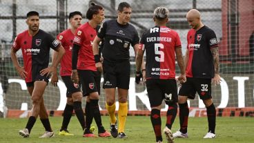 Los futbolistas rojinegros rodean al árbitro Echavarría en Sarandí.