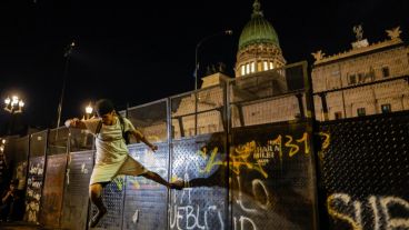 Un manifestante intentando derribar una valla al final de la marcha.