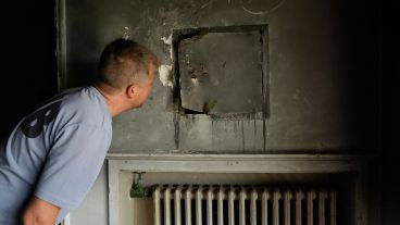 Lautaro D'Anna espía dentro de una caja de seguridad amurada en una habitación.