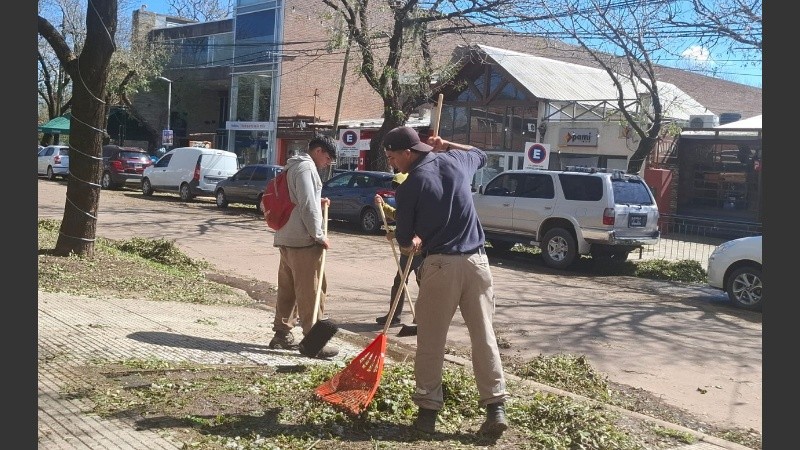 Jardineros municipales colaboraban en la remoción del resabio de granizo en las veredas.
