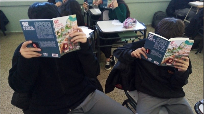 Alumnos de primer año del secundario leyendo El diario de Adriana Topo.