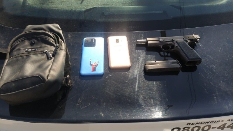 El arma y los celulares incautados a los sospechosos.