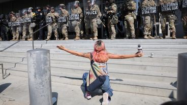 Una manifestante se arrodilla frente a miembros de la Guardia Nacional de California este lunes.