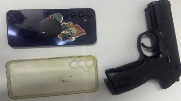 El arma de aire comprimido y el celular del gendarme.