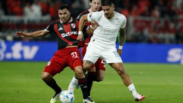 Marcos Acuña pelea una pelota con el ex Newell's Jorge Recalde.