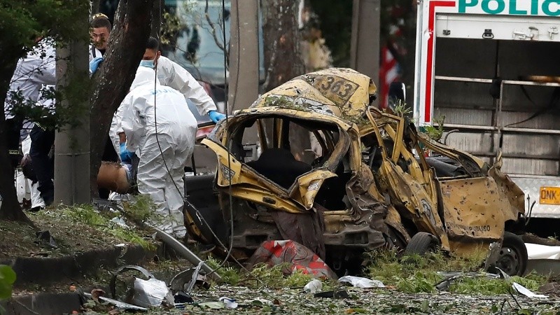La policía colombiana e Interpol inspeccionan el coche bomba detonado.