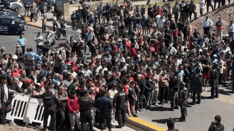 Una multitud aguardando por la mercadería siniestrada.