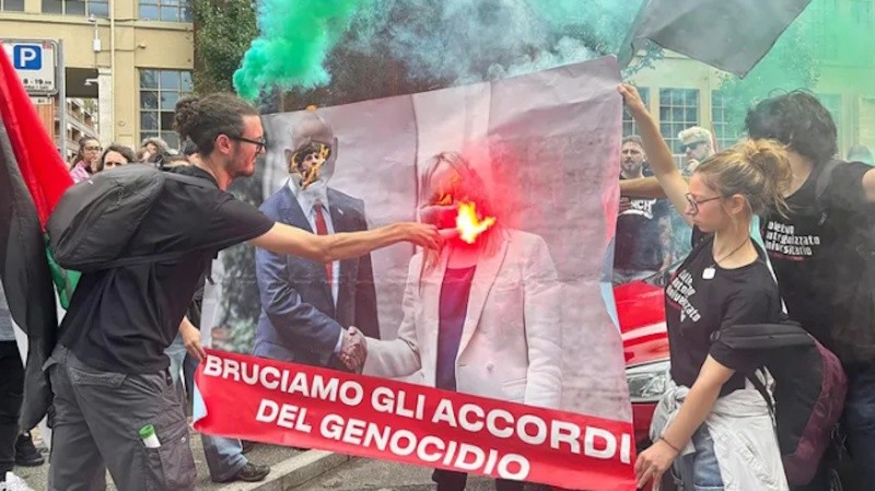 Manifestantes queman la foto con las imágenes de la primera ministra de Italia, Giorgia Meloni, y el primer ministro de Israel, Benjamín Netanyahu. 
