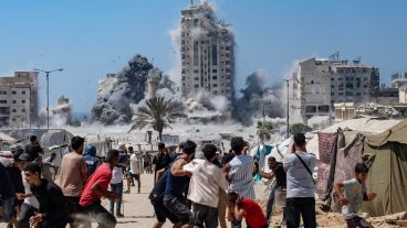 Un grupo de palestinos presencia el ataque israelí contra la Torre Mushtaha, en Gaza.