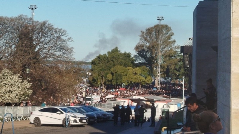 La humareda de fondo detrás de la multitud convocada en el Monumento.