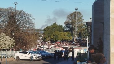 La humareda de fondo detrás de la multitud convocada en el Monumento.