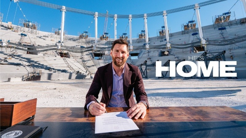 Leo estampando la firma en su nuevo contrato, en la escenografía del nuevo estadio en construcción