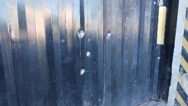El portón de la distribuidora tenía varios orificios de arma de fuego.