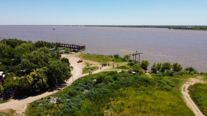 Vista aérea del predio, sobre la costa del Paraná y el límite norte con la calle de tierra y viviendas del barrio.