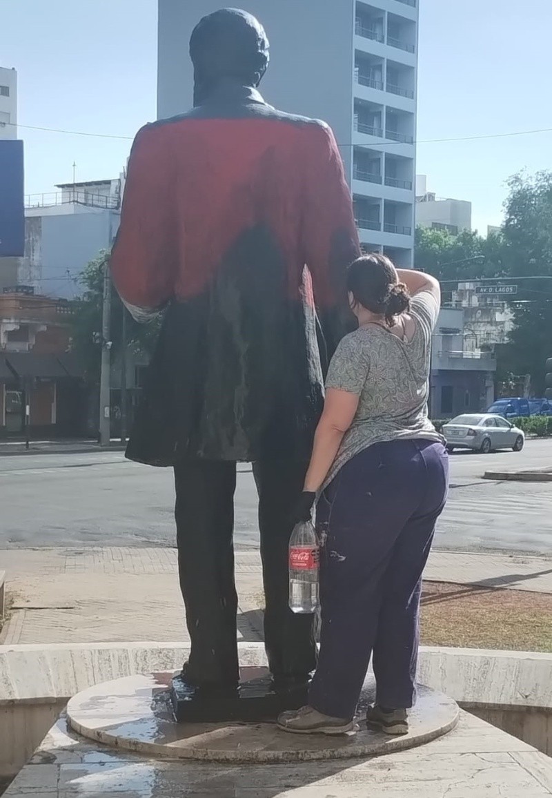  Una empleada municipal impia la pintada.