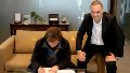Milei junto a Adorni al momento de la firma.