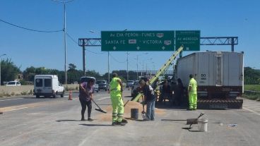 Personal de Corredores Viales trabajando para levantar el cereal derramado.