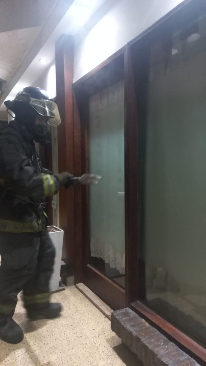 &nbsp;Bomberos forzando la puerta para ingresar.