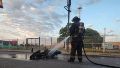 Bomberos apagando la moto incendiada.