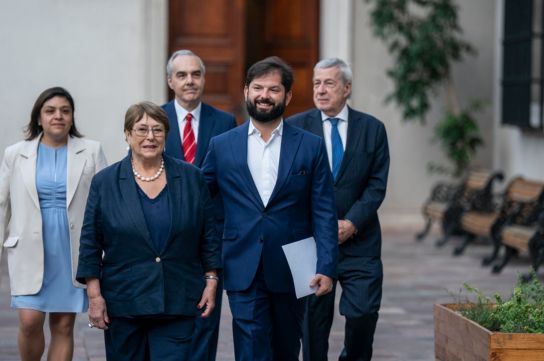 Boric junto a la expresidenta Michelle Bachelet caminando este lunes en el palacio de La Moneda.