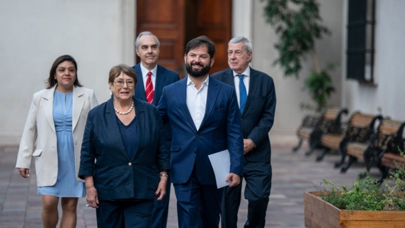 Boric junto a la expresidenta Michelle Bachelet caminando este lunes en el palacio de La Moneda.